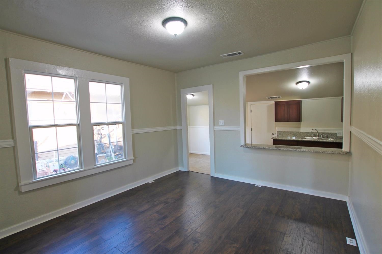 1115 M Street Reedley, CA 93654 - Photo 9 of 10 a view of a kitchen with an empty room and a window