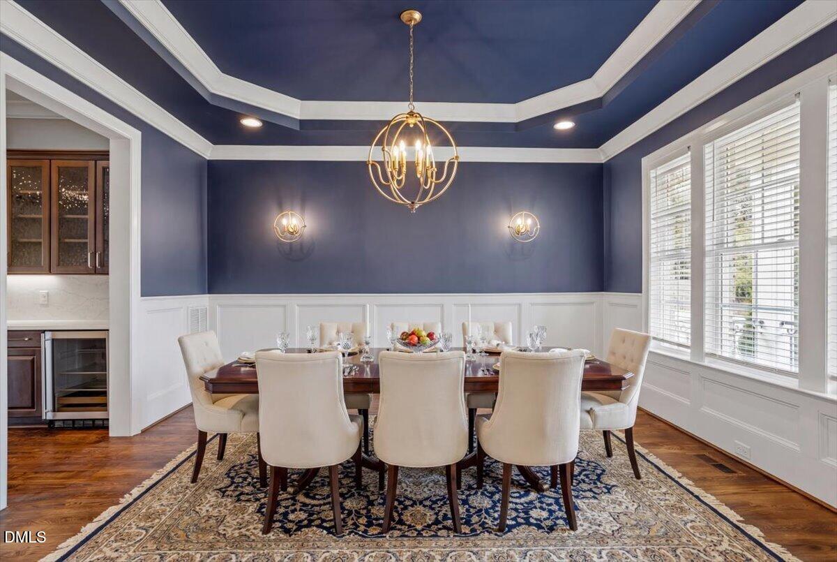 12616 Village Springs Road Raleigh, NC 27614 - Photo 15 of 89 a view of a dining room with furniture a chandelier and wooden floor