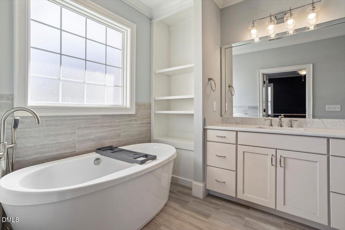 12616 Village Springs Road Raleigh, NC 27614 - Photo 60 of 89 a bathroom with a bathtub a sink and a window