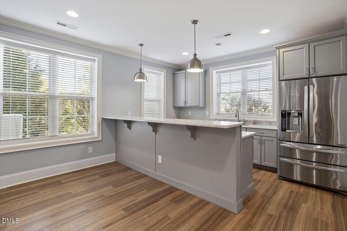 12616 Village Springs Road Raleigh, NC 27614 - Photo 71 of 89 a kitchen with stainless steel appliances granite countertop a refrigerator a sink dishwasher a stove and white cabinets with wooden floor