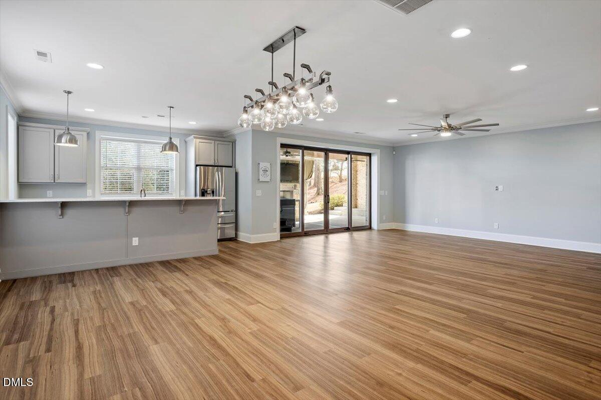12616 Village Springs Road Raleigh, NC 27614 - Photo 76 of 89 a view of an empty room with wooden floor and a kitchen