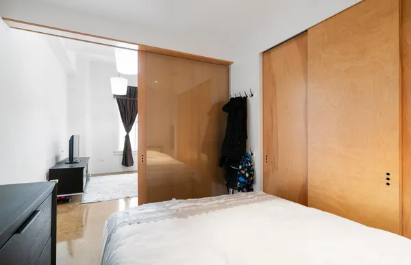 a bedroom with a bed and a large mirror