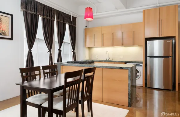a dining table with chairs and a refrigerator