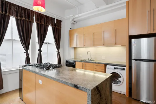 a kitchen with refrigerator a washer and a window