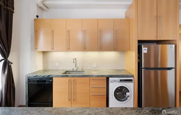 a kitchen with a refrigerator a stove a sink and cabinets