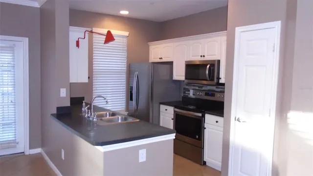 a kitchen with stainless steel appliances granite countertop a sink and a refrigerator