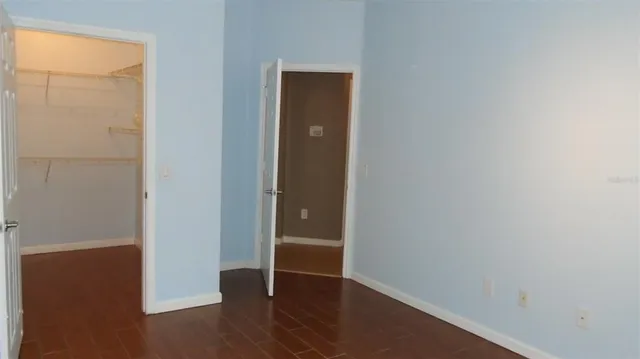 an empty room with wooden floor and closet