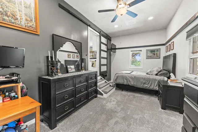 a bedroom with a bed and a flat tv screen on dresser
