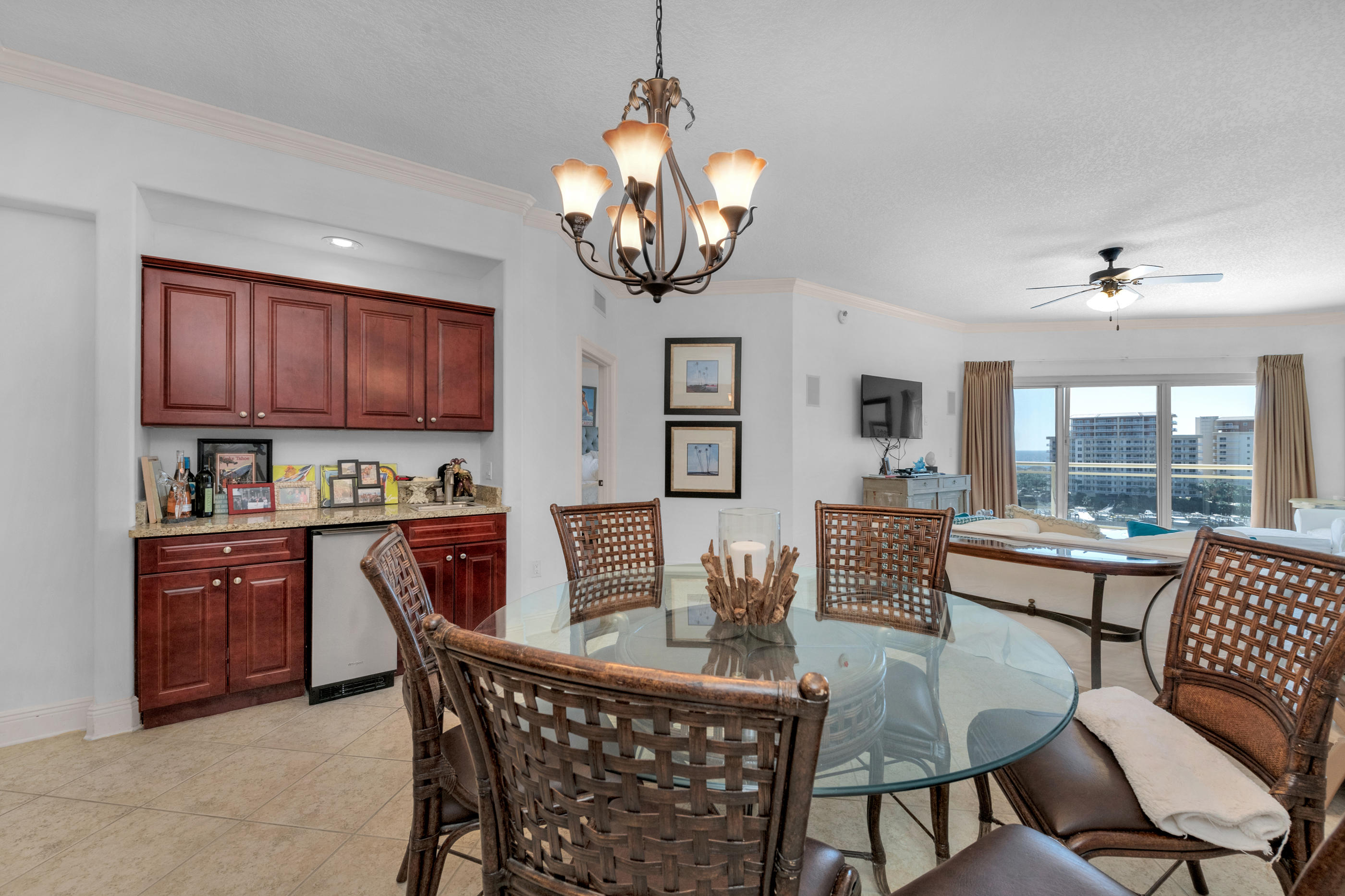 770 Harbor Boulevard, Unit 7E Destin, FL 32541 - Photo 12 of 38 a dining room with wooden floor a chandelier a wooden table and chairs