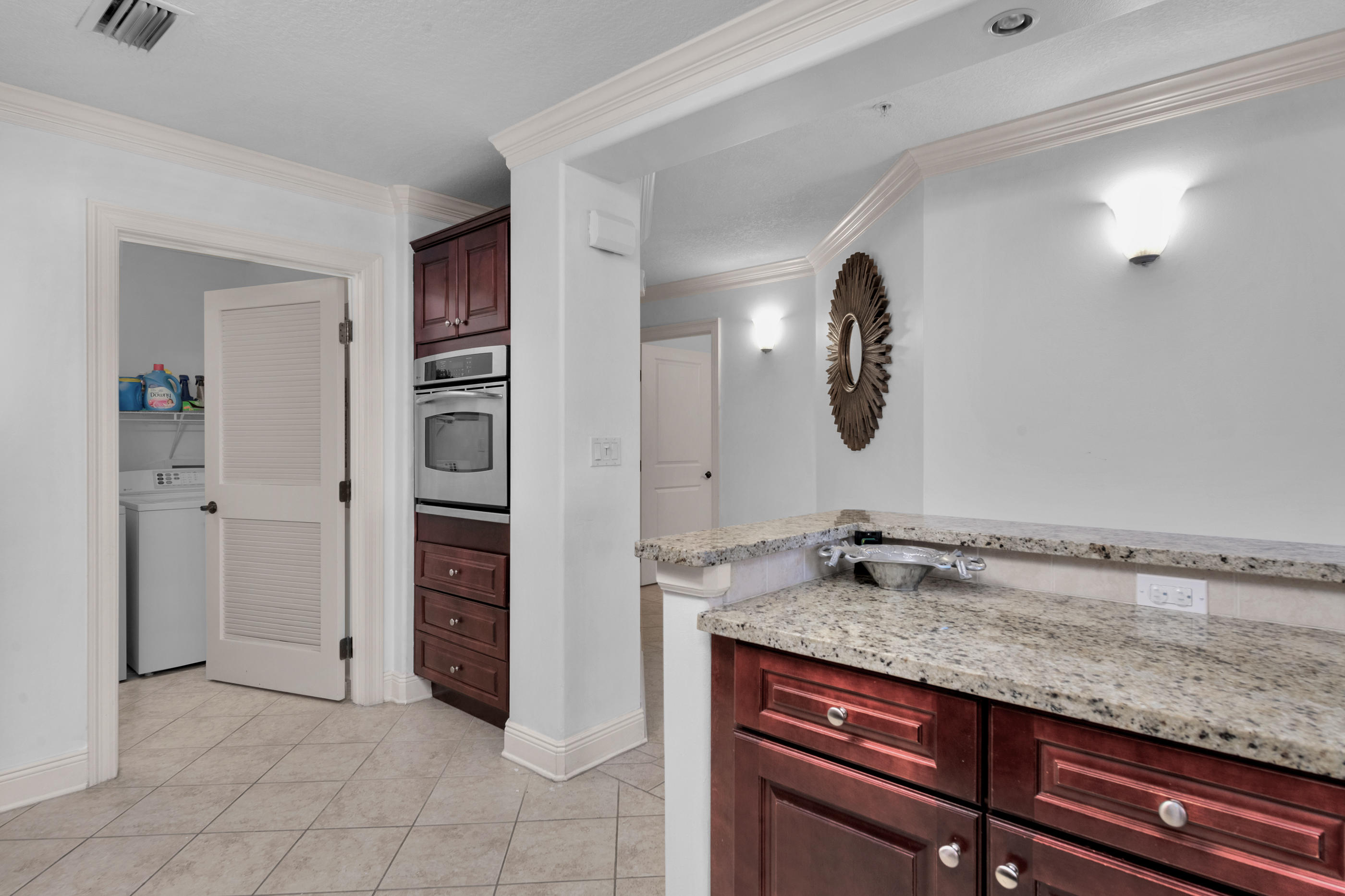 770 Harbor Boulevard, Unit 7E Destin, FL 32541 - Photo 10 of 38 a bathroom with a granite countertop sink and a mirror