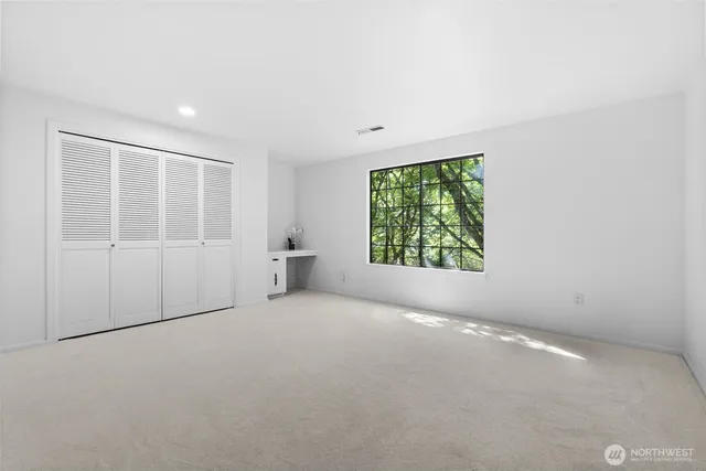 an empty room with windows and closet