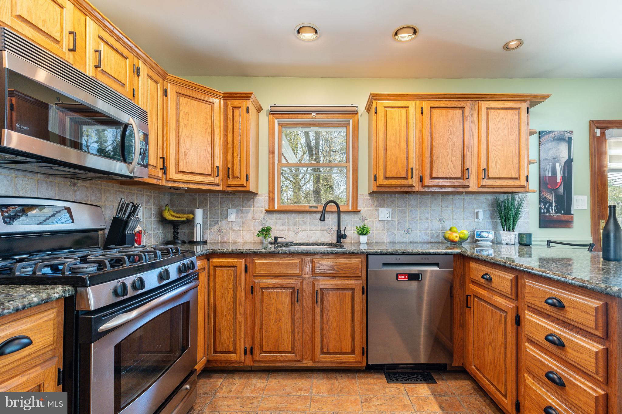 583 Lake Boulevard Lindenwold, NJ 08021 - Photo 13 of 51 a kitchen with stainless steel appliances granite countertop a stove top oven a sink dishwasher and cabinets with wooden floor
