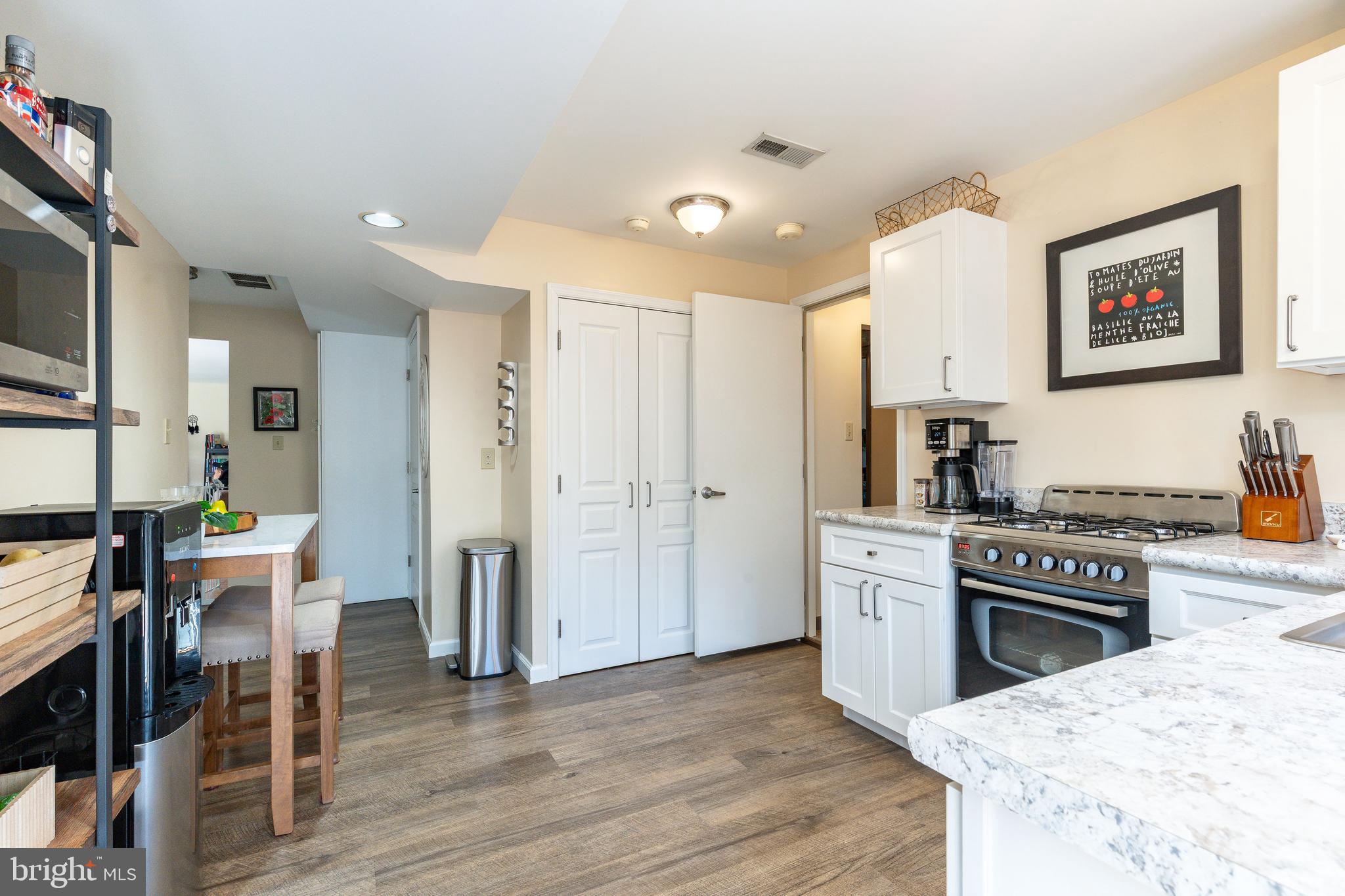 583 Lake Boulevard Lindenwold, NJ 08021 - Photo 39 of 51 a kitchen with stainless steel appliances granite countertop a stove top oven a dining table and chairs with wooden floor