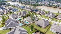 515 Mill Creek Road Pinehurst, TX 77362 - Photo 45 of 48 This aerial photo showcases the Woodtrace neighborhood with spacious homes, well-maintained yards, and several private pools. It's located near a scenic waterway, offering a tranquil and picturesque setting.