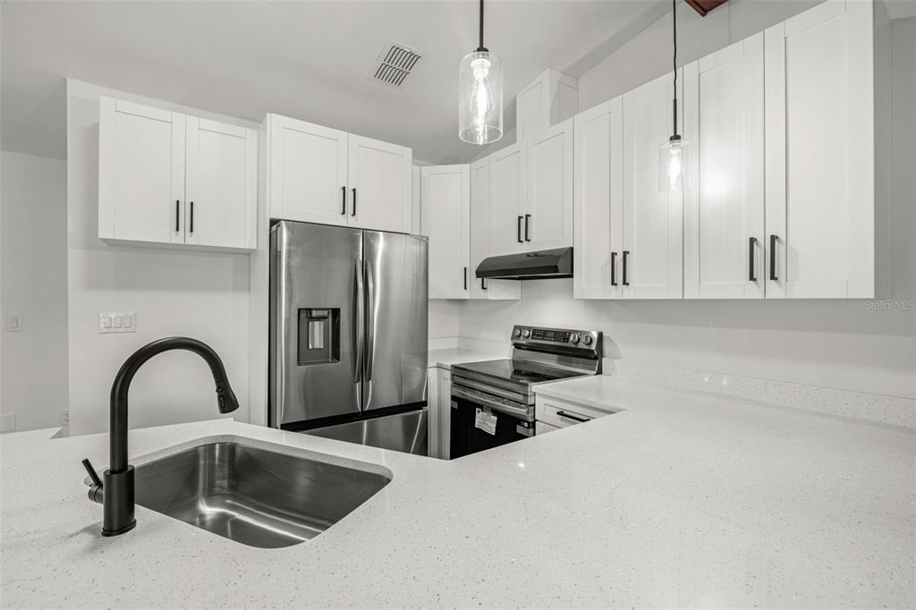 8082 Pagoda Drive Spring Hill, FL 34606 - Photo 10 of 28 a kitchen with stainless steel appliances a refrigerator sink and stove