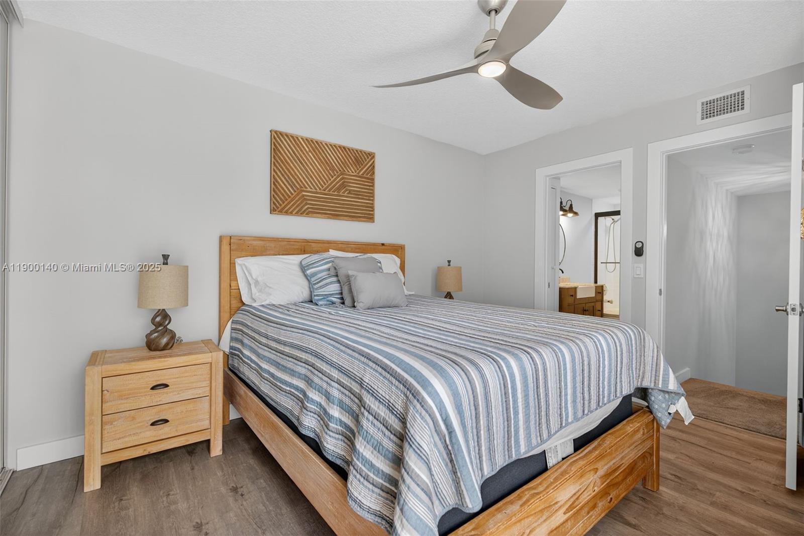 2701 27th Court, Unit 2701 Jupiter, FL 33477 - Photo 24 of 28 a bedroom with bed and wooden floor