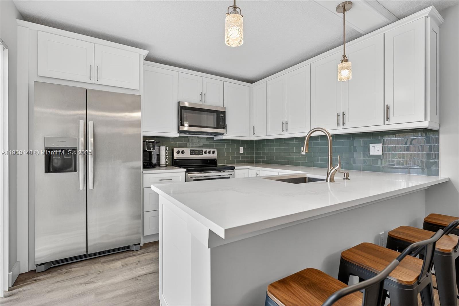 2701 27th Court, Unit 2701 Jupiter, FL 33477 - Photo 3 of 28 a kitchen with stainless steel appliances a refrigerator sink and cabinets