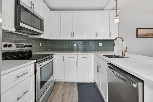 a kitchen with granite countertop white cabinets and white appliances