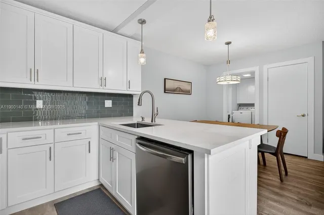 a kitchen with white cabinets appliances and wooden floor