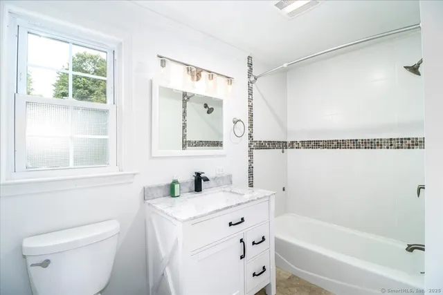 a bathroom with a sink a mirror toilet and bathtub