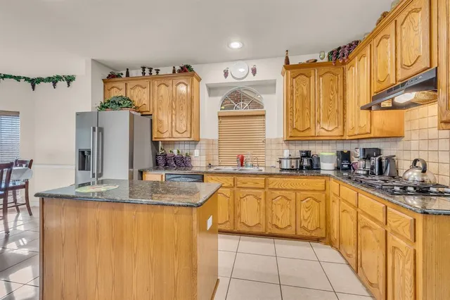 a kitchen with stainless steel appliances granite countertop a sink a stove and cabinets