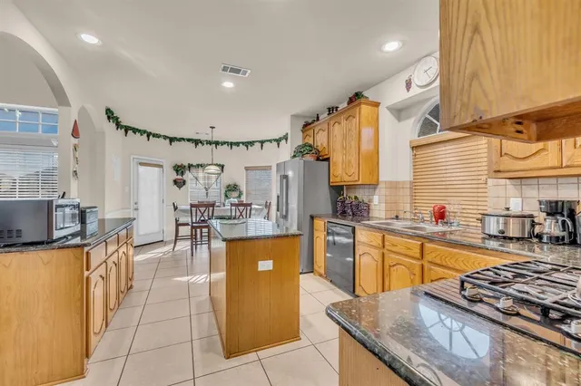 a kitchen with stainless steel appliances granite countertop a sink a stove and a refrigerator