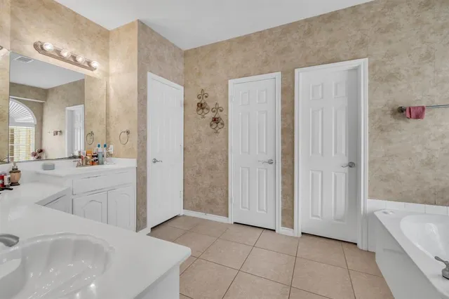 a spacious bathroom with a tub shower and sink