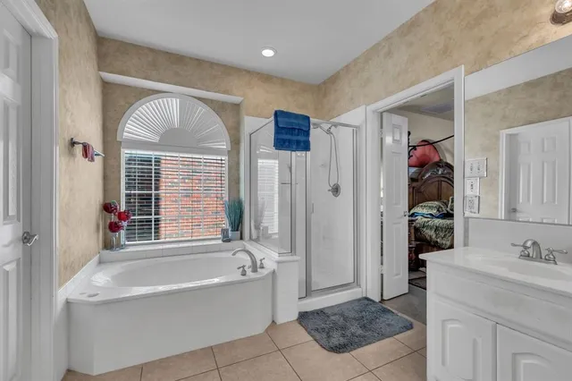 a bathroom with a tub sink and mirror