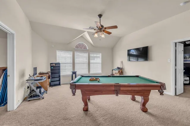 a room with pool table and windows