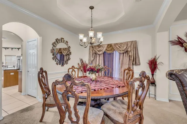 a view of a dining room with furniture and chandelier