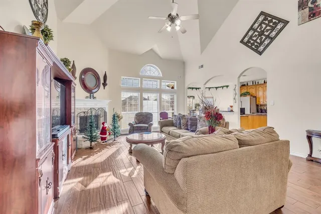 a living room with furniture kitchen view and a chandelier