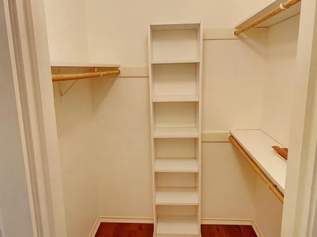 a view of walk in closet with empty racks