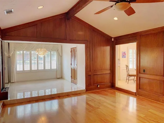a view of an empty room with window and wooden floor
