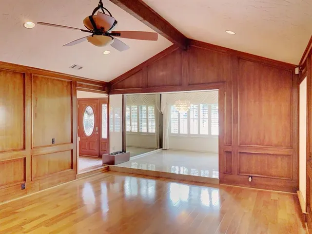 a view of an empty room with window and wooden floor