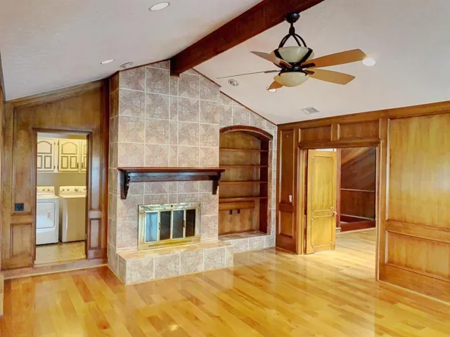 a view of an empty room with cabinet and a fireplace