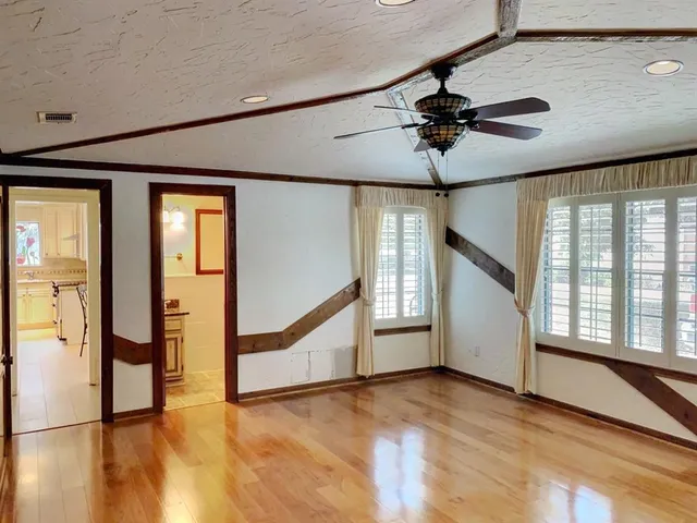 a view of a livingroom with wooden floor and a ceiling fan