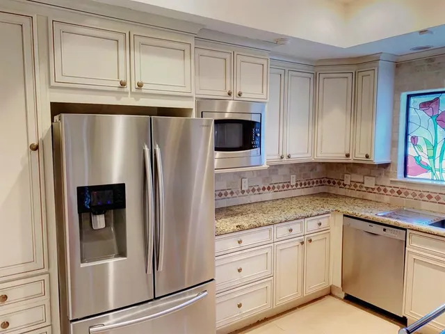 a kitchen with stainless steel appliances white cabinets and a refrigerator