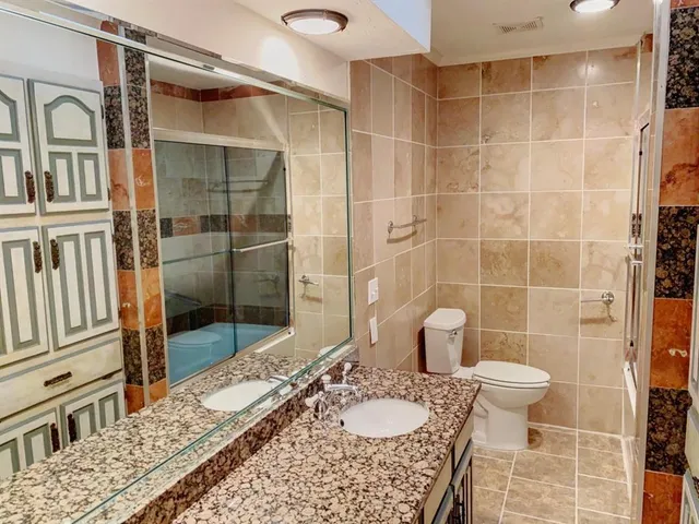 a bathroom with a sink toilet and shower