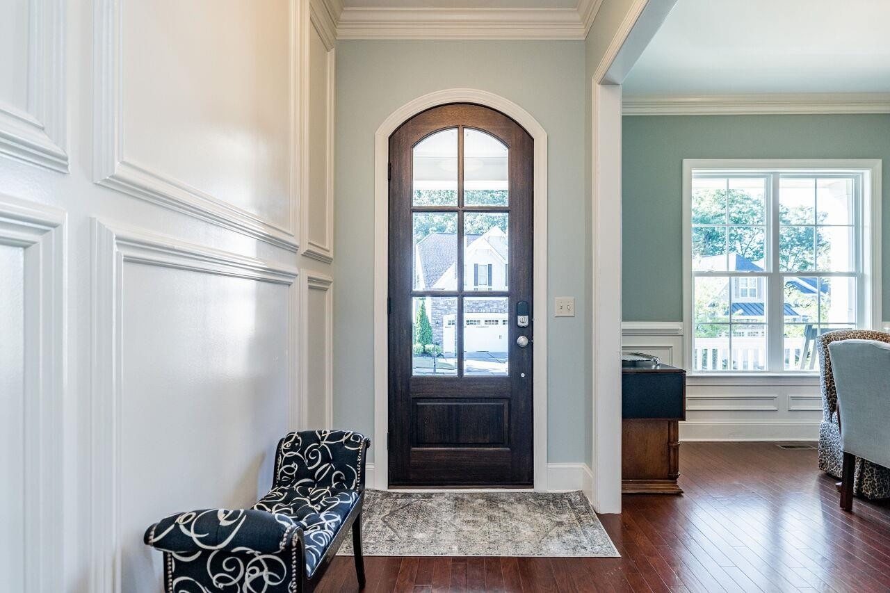 8035 Brandyapple Drive Raleigh, NC 27615 - Photo 3 of 30 Elegant foyer with arched wood glass front door, 10' Ceilings, wainscot to the ceilings and hardwood floors. Foyer