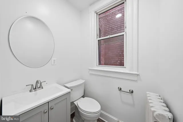 a bathroom with a sink a toilet and a mirror