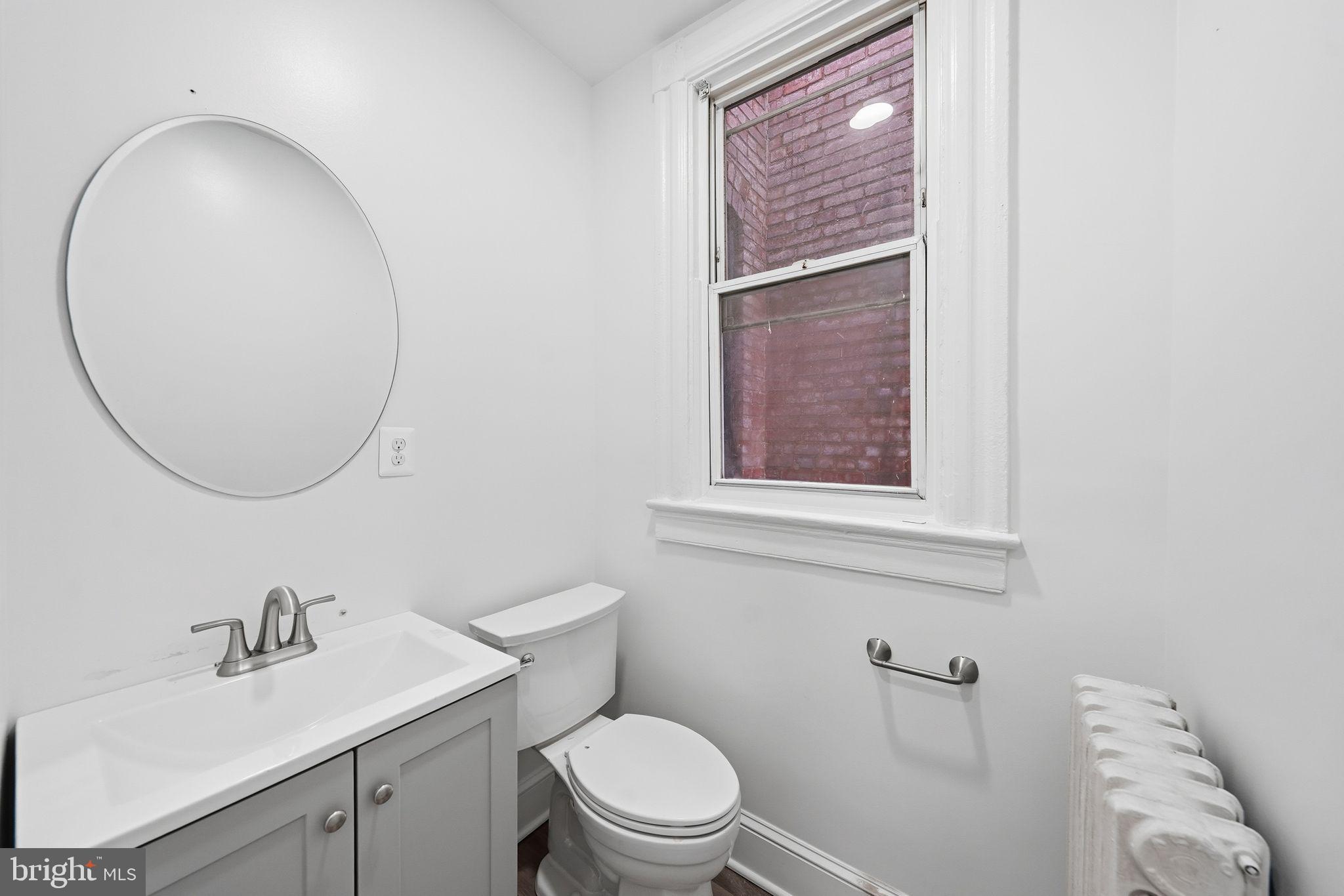 2032 North Capitol Street Northwest, Unit 1 Washington, DC 20002 - Photo 5 of 14 a bathroom with a sink a toilet and a mirror