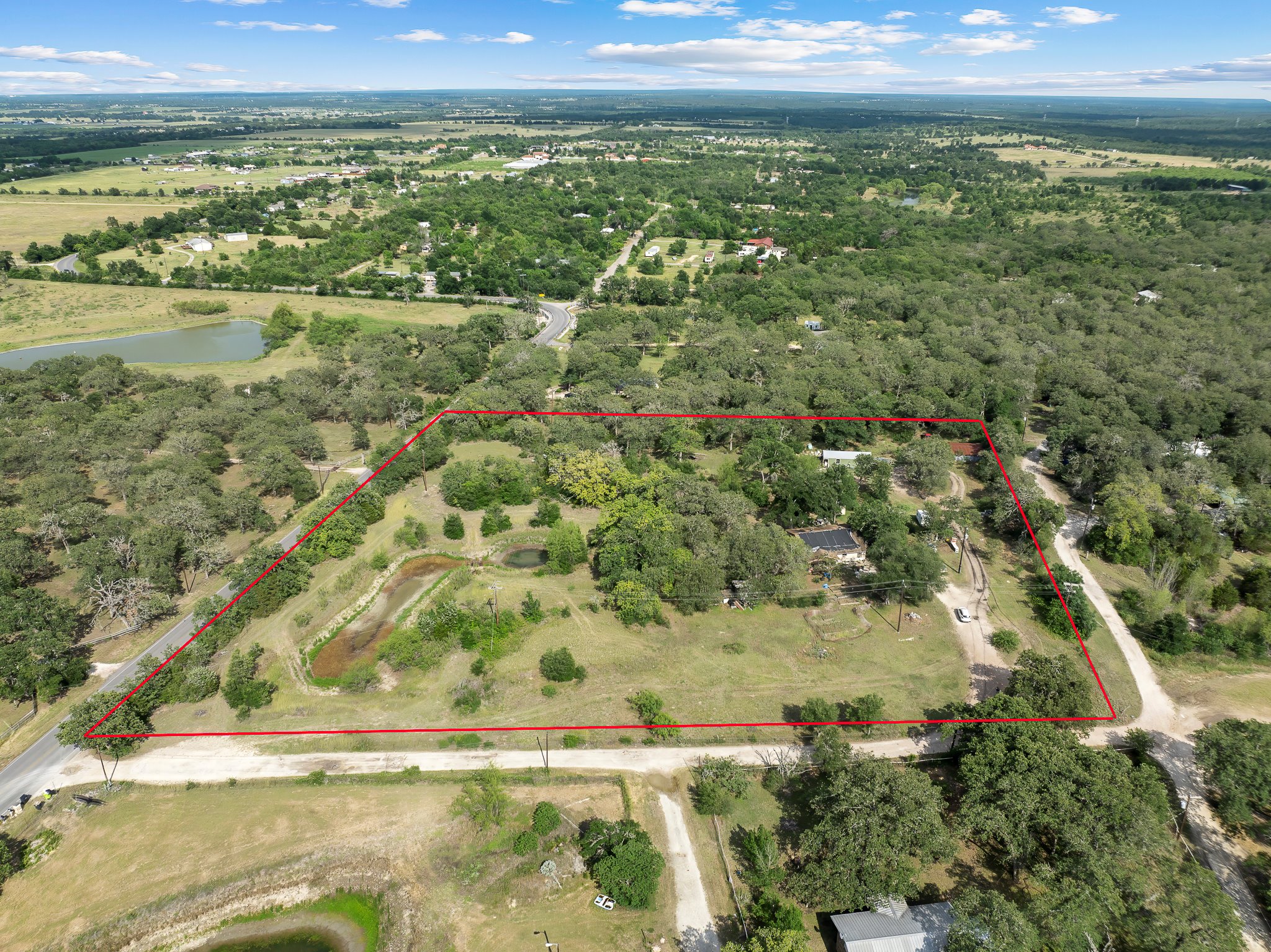 20905 Hogeye Road, Unit 1 Manor, TX 78653 - Photo 1 of 1 Aerial view of property and surrounding area with property parcel outlined and a large body of water