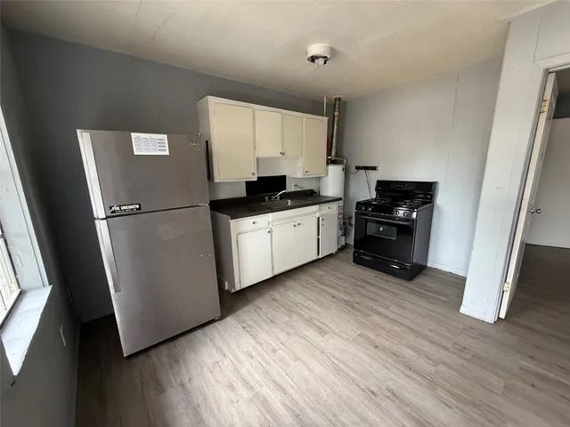 a kitchen with stainless steel appliances a refrigerator sink and wooden floor