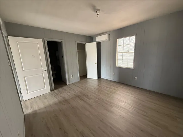 an empty room with windows and closet