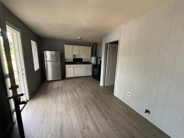 a large kitchen with a wooden floor and stainless steel appliances
