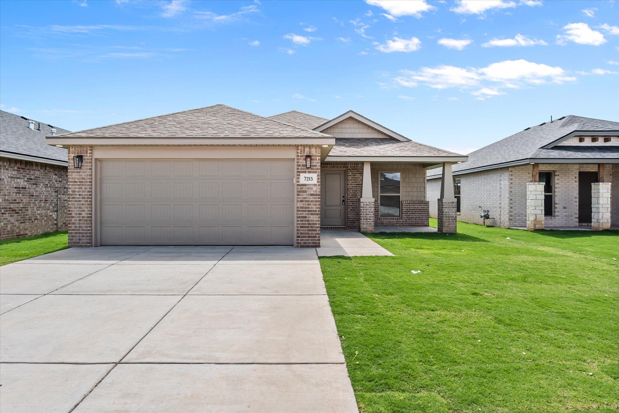 a front view of a house with a garden and yard
