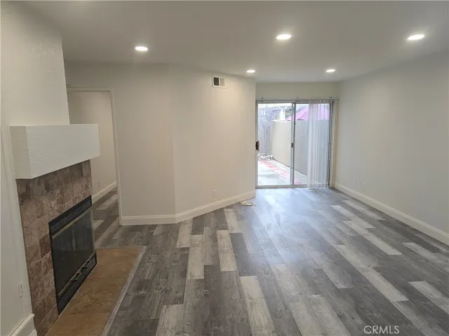 an empty room with wooden floor and fireplace