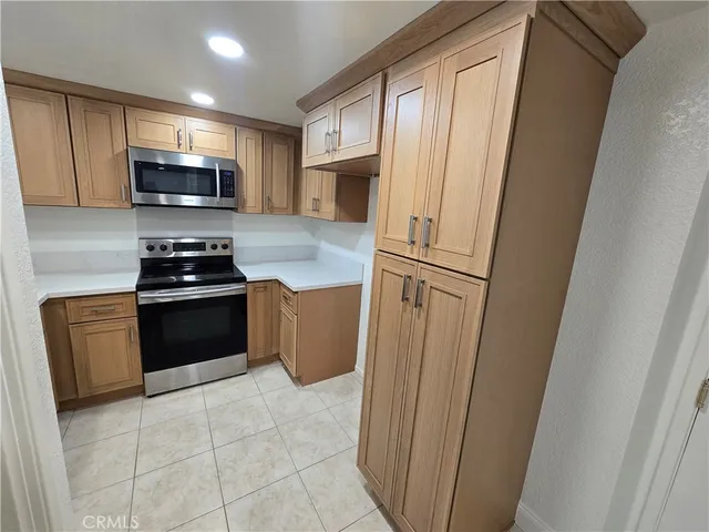 a kitchen with granite countertop a refrigerator stove and microwave