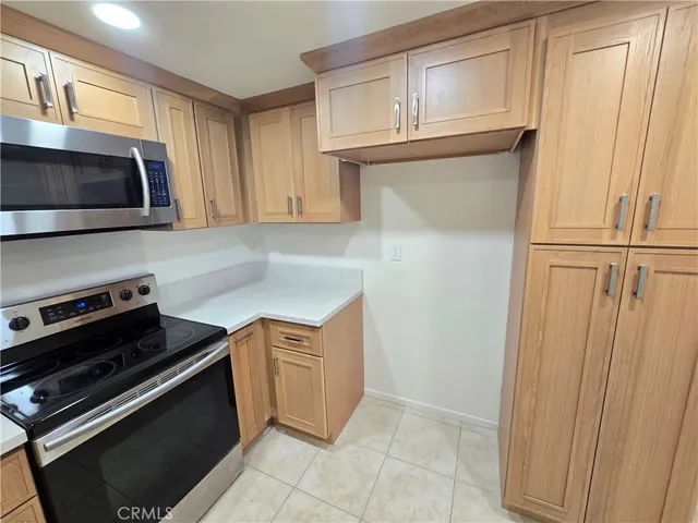 a kitchen with granite countertop a stove and a microwave