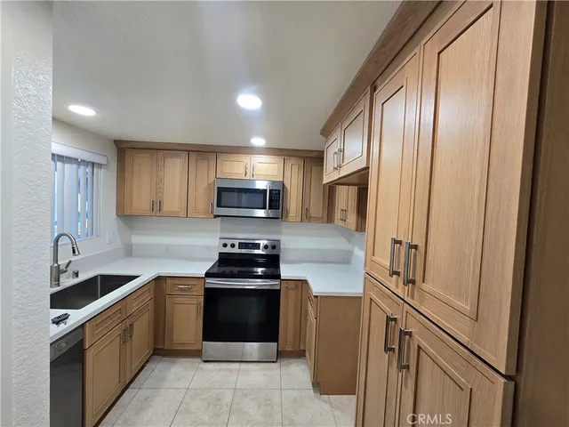 a kitchen with stainless steel appliances sink a microwave and cabinets